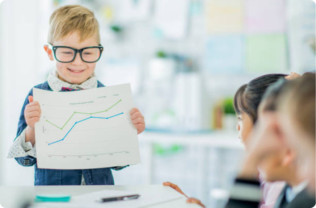 A young boy wearing glasses holding a line chart